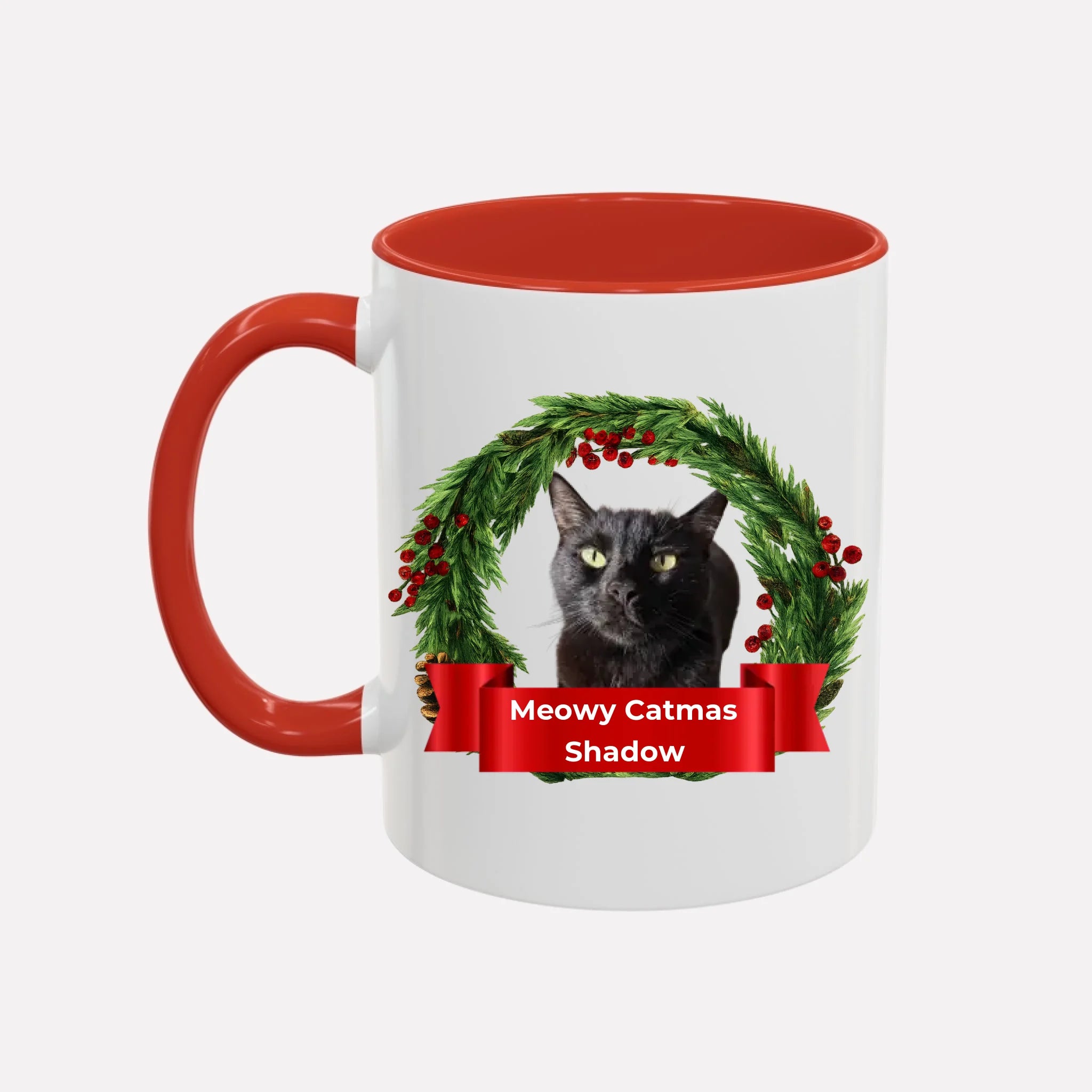 White sample mug with red interior and handle, featuring a black cat in a Christmas wreath and 'Meowy Catmas Shadow' text.
